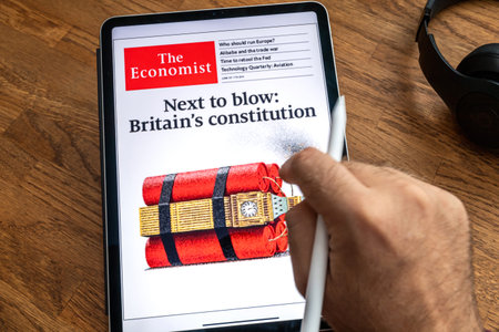 Paris, France - Jun 6, 2019: Man reading on Apple iPad Pro the newspaper The Economist about...