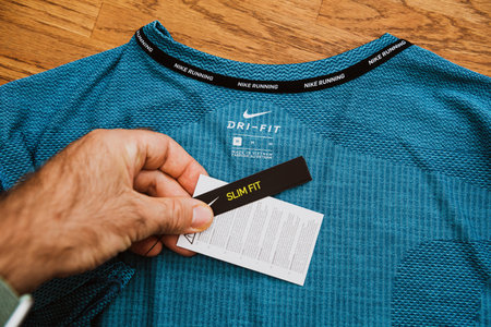 Paris, France - Jul 13, 2019: Man hand POV unboxing unpacking admiring latest sport clothes...