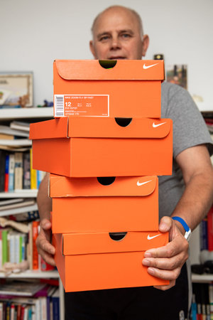 Paris, France - Jul 10, 2019: Athlete senior man holding in hands multiple red cardboards with Nike...
