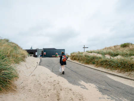 Overveen, Netherlands - Aug 16, 2018: Rear view of single Dutch woman walking to the beach on a cloudy dayのeditorial素材