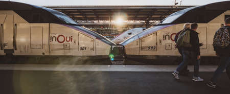 Paris, France - Oct 13, 2018: Wide image of TGV In OUI fast Train a Grande Vitesse on the railroad platform with group of three adult males walking in front of the trainのeditorial素材