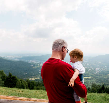 Baden-Baden, Germany - Jul 7, 2019: Senior father holding toddler with view over Baden-Baden valley from Merkurwegのeditorial素材