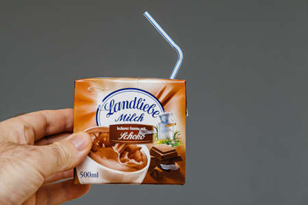 Paris, France - Mar 16, 2019: Man hand holding Landliebe Milch milk with chocolate tasteのeditorial素材