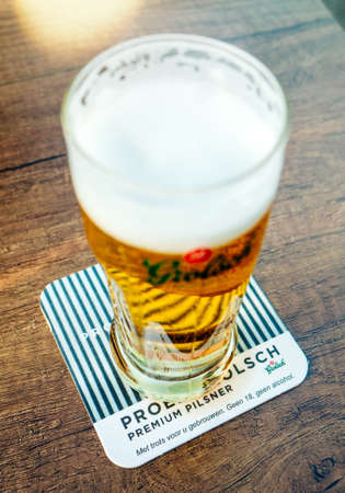 Overveen, Netherlands, - Aug 23, 2019: Vertical image of fresh Grolsch beer at Parnassia Cafe - Grolsch is Dutch brewery founded in 1615 by Willem Neerfeldt in Groenloのeditorial素材