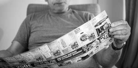Paris, France - May 22, 2019: Senior man holding flyer advertising featuring on the cover multiple household products offered by Expert Oehler - washing machines, expressos, fridges, ironsのeditorial素材