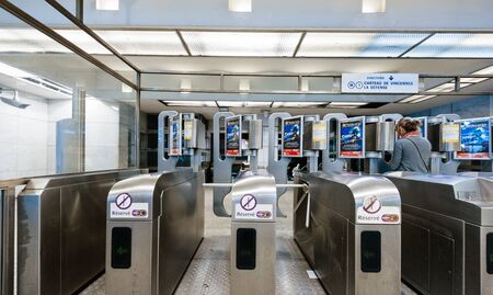 Paris, France - Jul 14, 2011: Woman passing through security metro barriers in Parisian underground metropolitan wirth direction to Chateau de Vincennes and La Defenseのeditorial素材