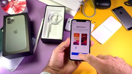 Paris, France - Sep 20, 2019: Man hand unboxing unpacking new latest Apple Computers iPhone 11 Pro and 11 Pro Max smartphone triple-lens camera and new technology - iOS 13 dark light modeのeditorial素材