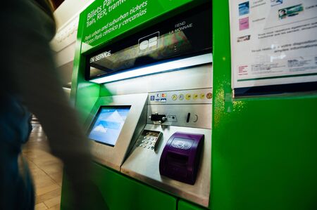 Paris, France - Jul 14, 2011: Silhouetes of woman buyuing purchaisng tickets for metro rer tramway tickets at the green vending machineのeditorial素材