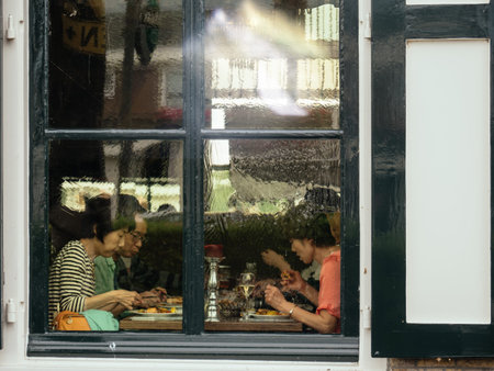 Kinderdijk, Netherlands - Aug 29, 2018: Street view of group Of Chinese people tourist eating in...