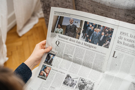 Paris, France - Sep 27, 2019: Woman reading Le Figaro in living room newspaper following the death of former French President Jacques Chirac at the age of 86 yearsのeditorial素材