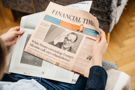 Paris, France - Sep 27, 2019: Woman reading Financial Times in living room newspaper following the death of former French President Jacques Chirac at the age of 86 yearsのeditorial素材