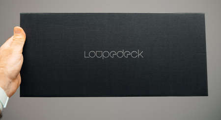 Paris, France - Spe 13, 2019: POV of man holding cardboard box during unboxing of new Loupedeck Plus photo and video editing console - front view with icon insigniaのeditorial素材