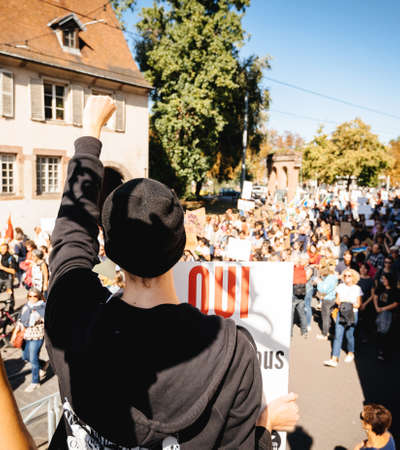 Strasbourg, France - Sep 21, 2019: Man with raised hand over crowd at the largest worldwide climate march change started by Swedish climate activist Greta Thunbergのeditorial素材