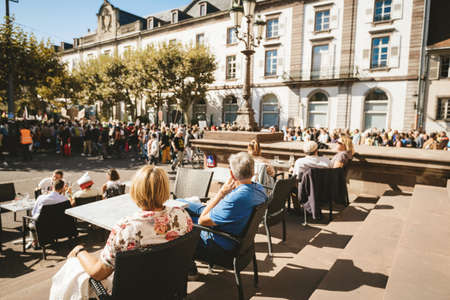 Strasbourg, France - Sep 21, 2019: People at cafe restaurant looking at the silhouette of protesters at the largest worldwide climate march change started by Swedish climate activist Greta Thunbergのeditorial素材