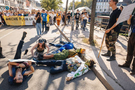 Strasbourg, France - Sep 21, 2019: Die-in protesters on asphalt with placards at the largest worldwide climate march change started by Swedish climate activist Greta Thunbergのeditorial素材