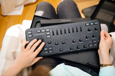 Paris, France - Spe 13, 2019: Woman video editor vlogger retoucher holding unboxing new Loupedeck Plus photo and video editing console manufactured by the Finnish company