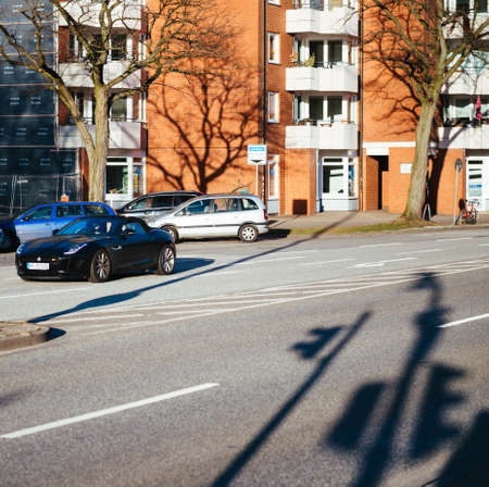 Hamburg, Germany - Mar 2018: Jaguar coupe car driving fast on German street with shadows of the traffic lights on the asphaltのeditorial素材