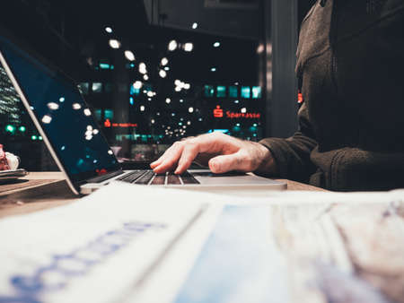 Frankfurt, Germany - Nov 30 2017: male hand working in German cafe with Sparkasse bank icon on the other side of the streetのeditorial素材