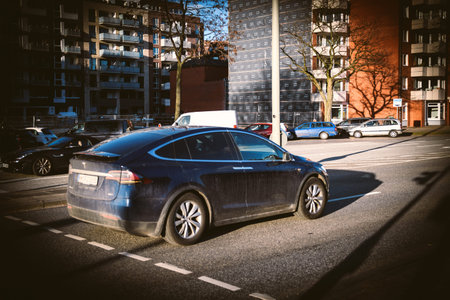 Hamburg, Germany - Mar 2018: Side view of black Tesla Model X electric car driving fast on German...