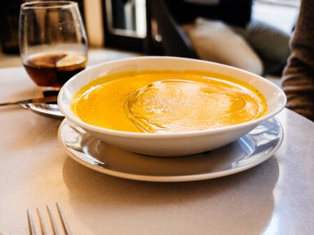 Close-up view of woman eating traditional Catalan Spanish pumpkin soup in Barcelona restaurantの写真素材