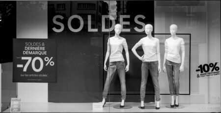 Paris, France - Jul 27, 2017: Soldes inscription with mannequins wearing elegant clothes and special last minutes 70 percent discount sales for fashion products on central Avenue - black and white imageのeditorial素材