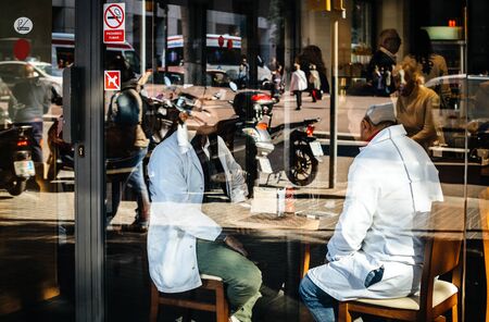 Barcelona, Spain - Nov 2017: View from the street of couple discussing inside bar cafe terrace in Barcelona drinking a Coca Cola canのeditorial素材