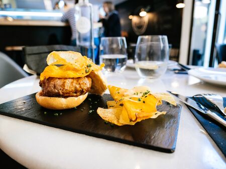 Close-up of typical Catalan burger with fried long potatoes served on a black marble surfaceの写真素材