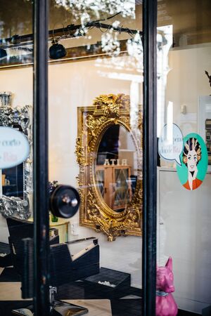 Barcelona, Spain - Nov 11 2017: Street view of empty chair in the barber shop in front of a golden mirrorのeditorial素材