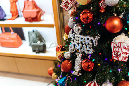 Beautiful Merry Xmas Christmas holiday fir tree decorated with red globes popcorn fresh boxes and candiesのeditorial素材