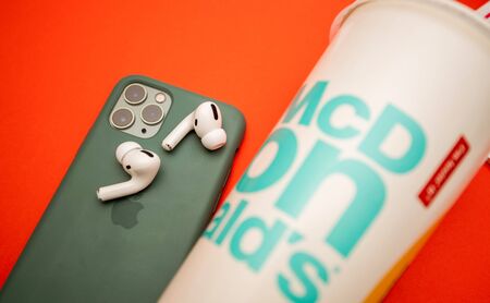 Paris, France - Oct 30, 2019: New Apple Computers AirPods Pro headphones with Active Noise Cancellation for immersive sound next to iPhone 11 Pro and McDonalds Cupのeditorial素材