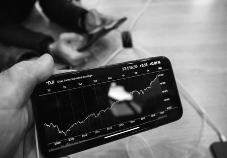 Paris, France - Nov 3, 2017: Man hand customer looking at Stocks app for AAPL stock price inside...