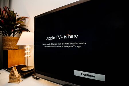 Paris, France - Nov 1, 2019: Side view of Apple TV plus is here message on living room display with try for free continue button - wide Panasonic plasma OLED tv setのeditorial素材