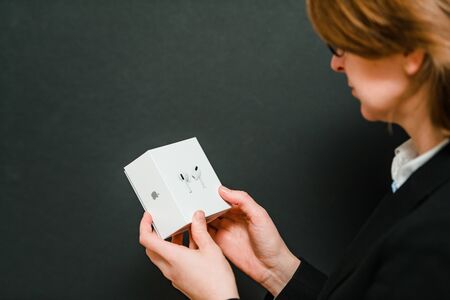Paris, France - Oct 30, 2019: Elegant woman holding in hands unboxing new Apple Computers AirPods Pro headphones with Active Noise Cancellation for immersive soundのeditorial素材