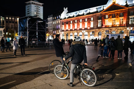 Strasbourg, France - Nov 23, 2017: Rear view of young boys on bicycle admiring the decorated Place...