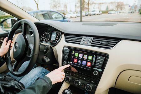 Strasbourg, France - Dec 13, 2016: Woman inside luxury car interior with Apple CarPlay system on the large digital dashboard with all apps on the digital screenのeditorial素材