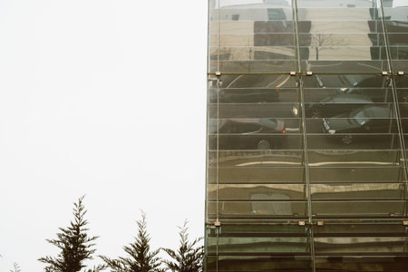 Reflection of cars waiting in traffic jam in the tall glass building