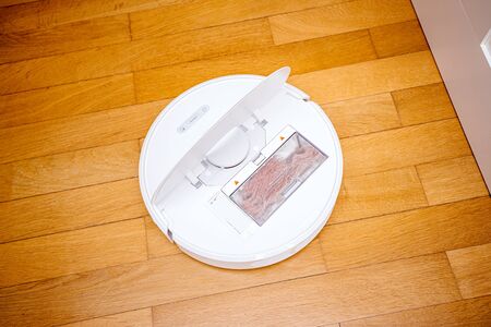 Paris, France - Nov 20, 2019: Latest Roborock S6 the flagship product of Roborock overhead view on the parquet floor with open plastic lid and full chamber with dust after cleaning the houseのeditorial素材