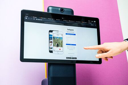 Paris, France - Oct 29, 2019: Woman hand testing Instagram app on Portal smart display by Facebook that provide video chat via Facebook Messenger WhatsApp and camera trackingのeditorial素材