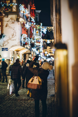Strasbourg, France - Dec 20, 2016: Busy Rue du Maroquin decorated for Christmas annual Market Marche de Noel with woman taking photograph on the smartphoneのeditorial素材