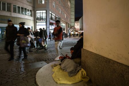 Strasbourg, France - Dec 24, 2018 Defocused pedestrians silhouettes walking near the beggar man with dog on corner of the central French streetのeditorial素材