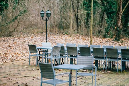 Multiple chaiars and tables in the fall park outdoor patio terrace in parkのeditorial素材