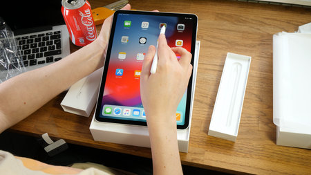 Paris, France - Feb 1 2019: Overhead view of young IT woman unboxing the latest Apple Computers iPad...