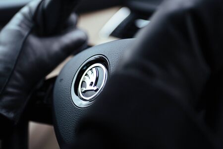 Paris, France - Jan 7, 2018: Woman wearing warm mittens gloves while holding the steering wheel of a luxury Skoda electric hybrid SUV limousine car on a winter cold dayのeditorial素材