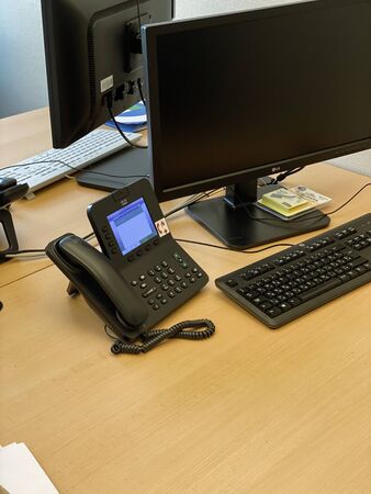 Paris, France - Dec 17, 2019: View of modern Cisco VOIP video phone on the table next to HP keyboard and LG monitor - working environmentのeditorial素材