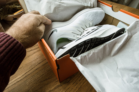 Paris, France - Sep 23, 2019: POV man hand over box performing the unbpxing unpacking of new pair of...