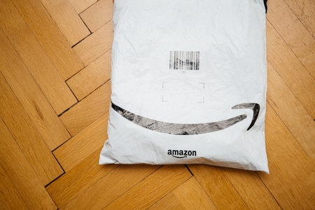 Paris, France - Jul 31, 2019: Thrown on parquet floor the fresh received parcel by Amazon Prime with smile arrow logotypeのeditorial素材