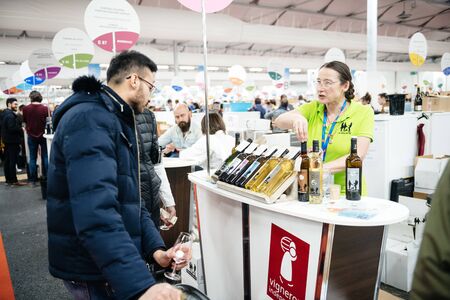 Strasbourg, France - Feb 16, 2020: Woman talking with visitor at the Vignerons independant English: Independent winemakers of France wine fair for private and horeca customersのeditorial素材
