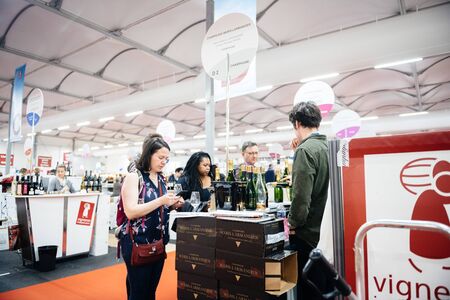Strasbourg, France - Feb 16, 2020: Side view of Visitors people tasting French wine at the Vignerons independant English: Independent winemakers of France wine fair for private and horeca customersのeditorial素材