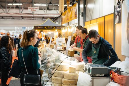 Strasbourg, France - Feb 16, 2020: Seller cutting product to customers at French wine at Vignerons independant exibition congress English: Independent winemakers of France wine fairのeditorial素材