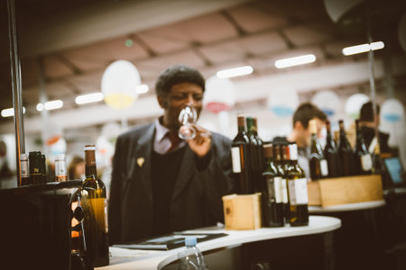 Strasbourg, France - Feb 16, 2020: Defocused silhouette of black ethnicity sommelier tasting wine at...